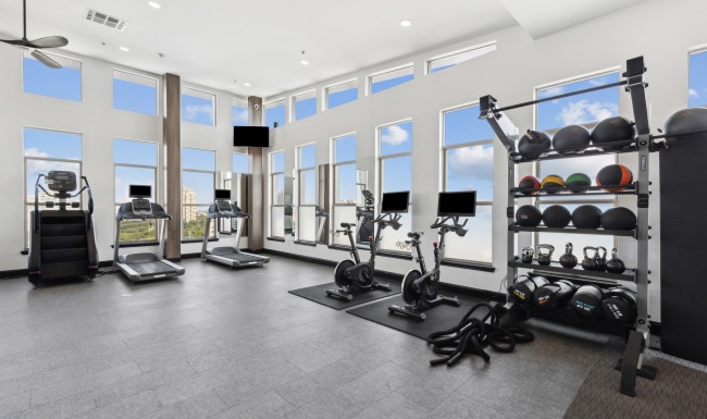 Luxury for a Lifetime cardio equipment in front of large windows in fitness center