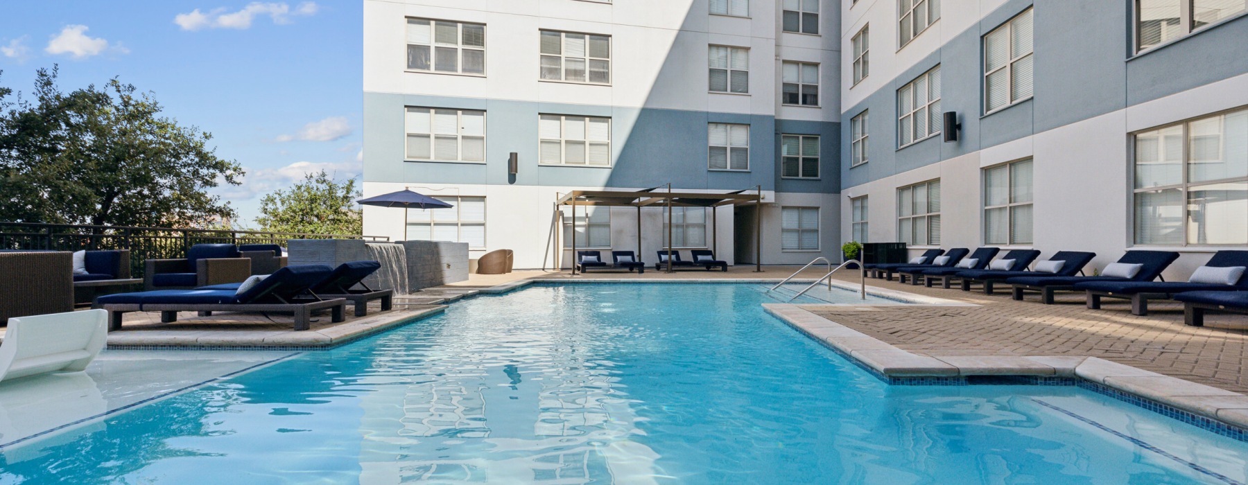 lounge area next to pool with water feature