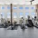 natural lighting pours through large windows wrapping around rooftop fitness center